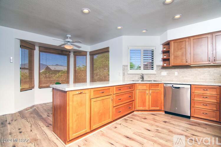 A kitchen with wooden cabinets and a stainless steel dishwasher.