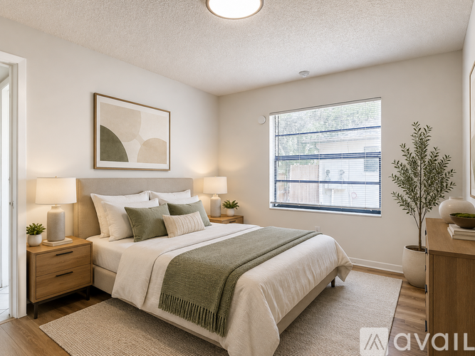A bedroom with a bed, nightstands, and a window.