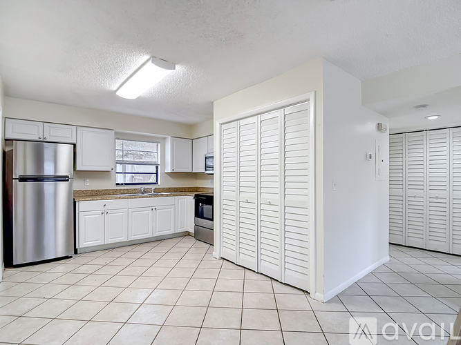 A kitchen with white cabinets and appliances.