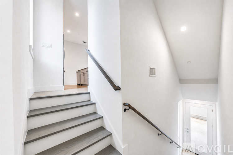 A staircase with a metal handrail and wooden steps.