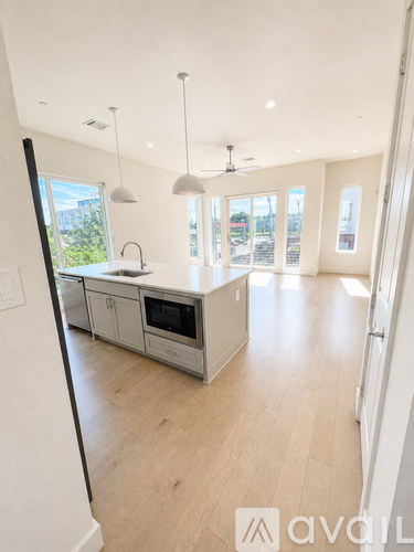 A modern kitchen with a large island and a view of the backyard.