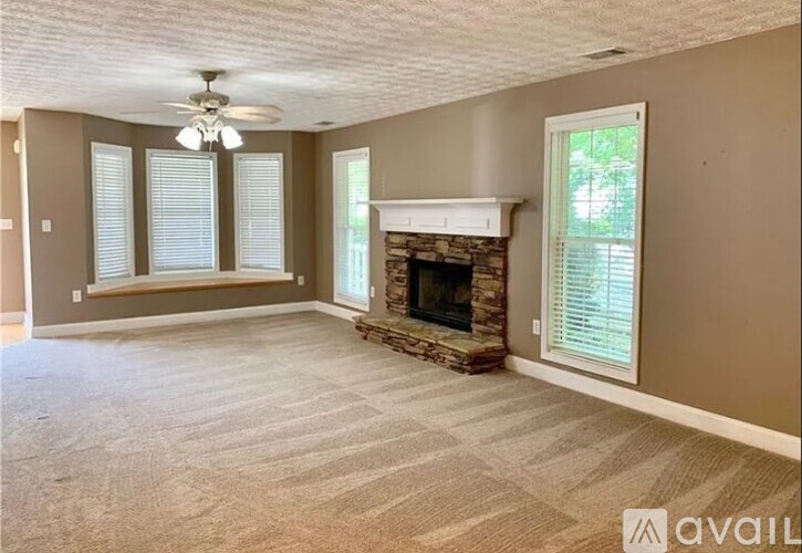 A living room with a fireplace and a fan on the ceiling.