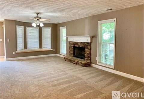 A living room with a fireplace and a fan on the ceiling.