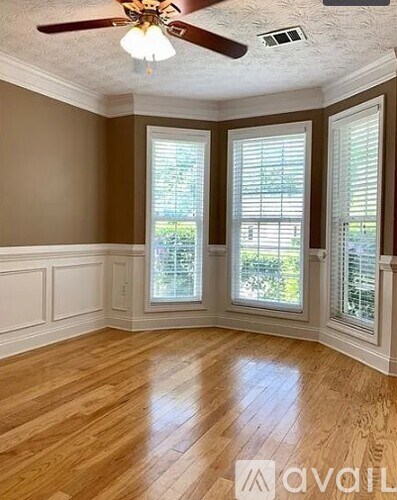 A room with wooden floors and a ceiling fan.