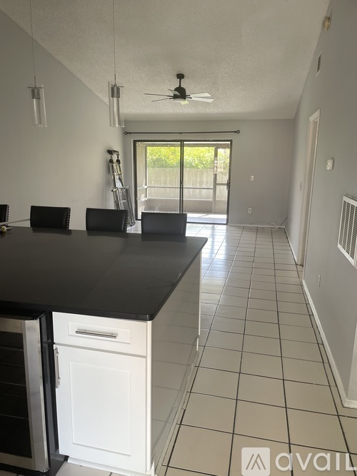A kitchen with a black countertop and white cabinets.