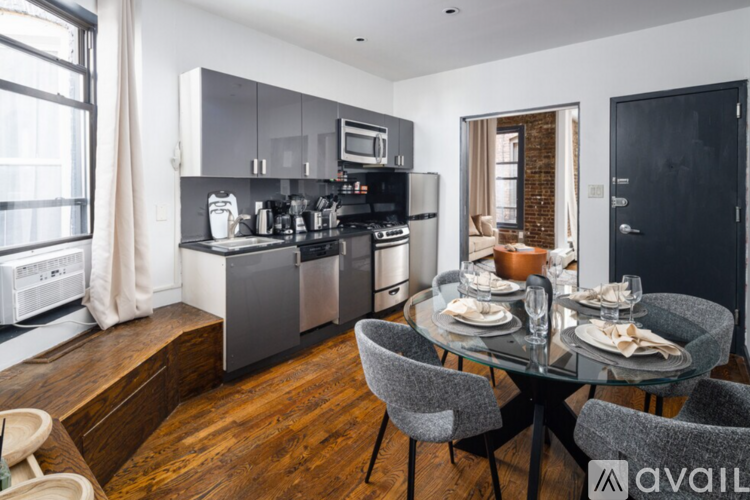 A modern kitchen with a dining table set for two.
