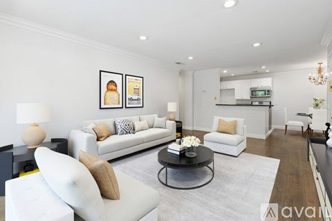 A living room with a white couch, a coffee table, and a chandelier.