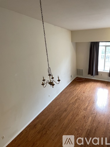 A room with wooden floors and a chandelier hanging from the ceiling.