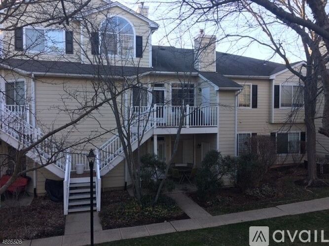 A house with a white fence and a tree in front.