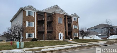 A large brick apartment building with a balcony on the second floor.