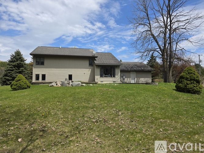 A house with a grey roof and a green lawn in front.