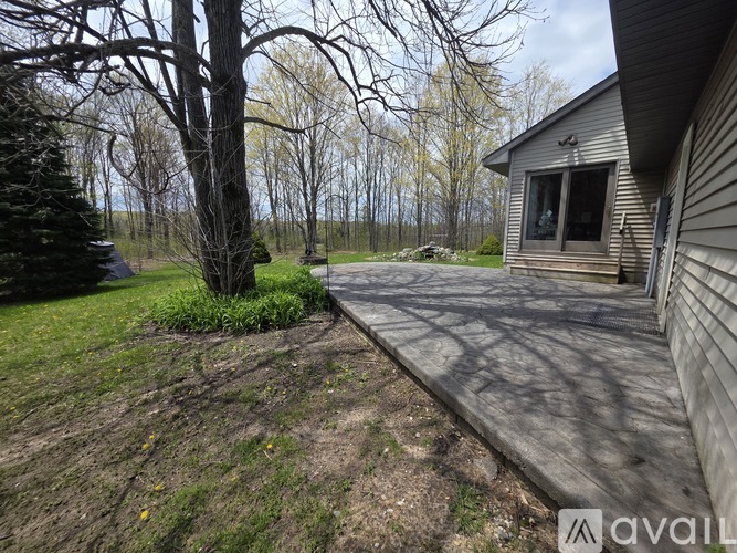 A house with a backyard and a tree in front of it.