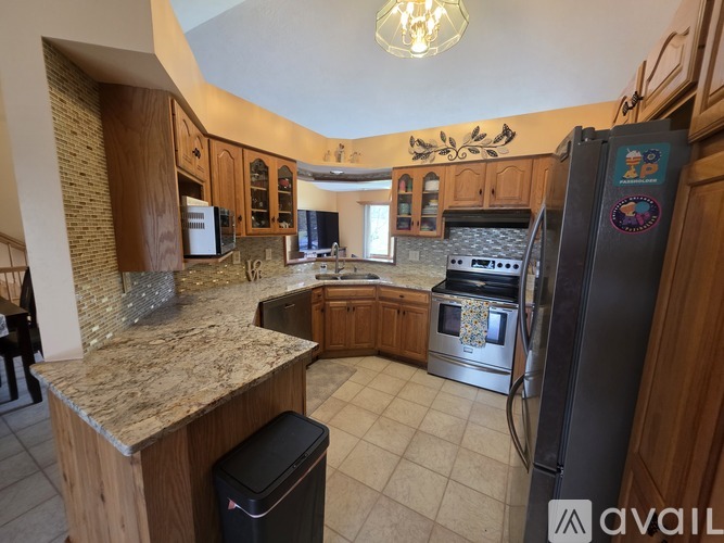 A kitchen with granite countertops and wooden cabinets.