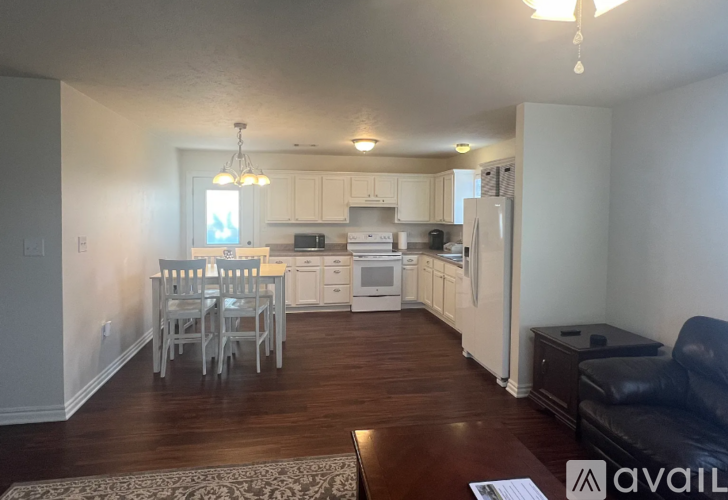 A kitchen with white cabinets and a dining table with chairs.