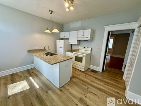A kitchen with a granite countertop and white appliances.