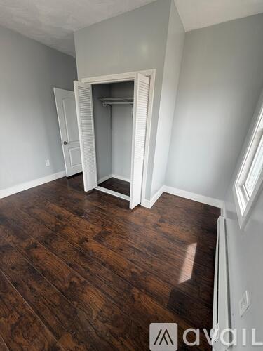 A room with wood flooring and a white door.