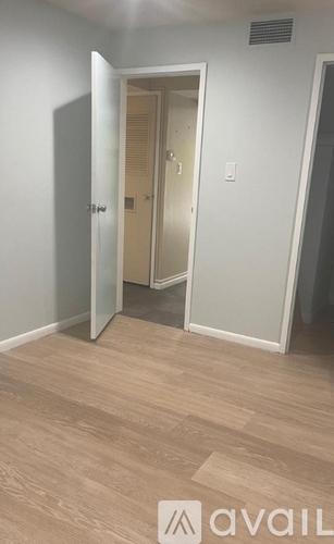 A room with a wooden floor and a white door.