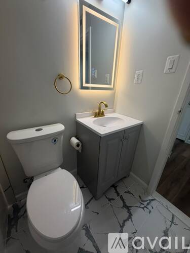 A bathroom with a toilet, sink, and mirror.