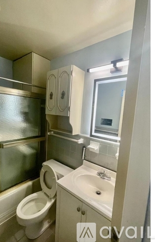 A bathroom with a toilet, sink, and medicine cabinet.