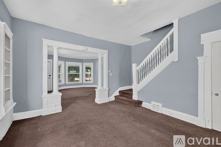 A spacious room with a staircase and a window.