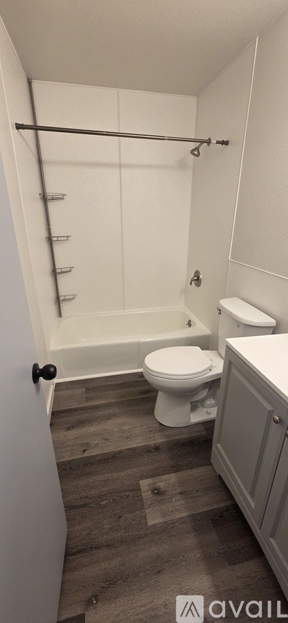 A bathroom with a toilet, sink, and a walk-in shower.