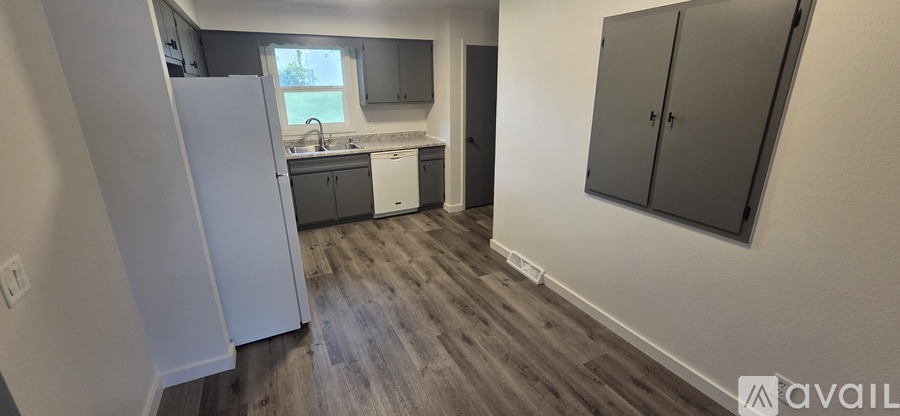 A kitchen with a white refrigerator and dark wood floors.