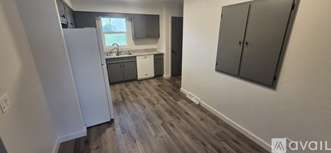 A kitchen with a white refrigerator and dark wood floors.