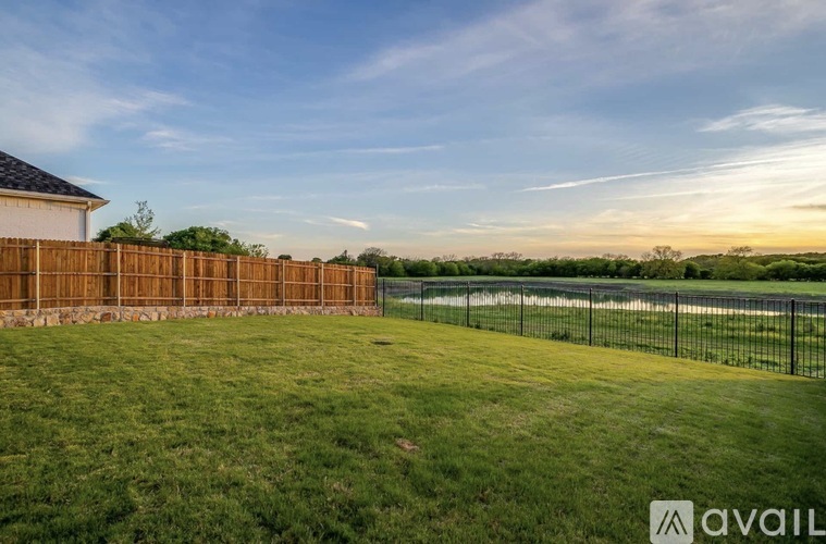 A house with a fence and a grassy yard is available for sale.