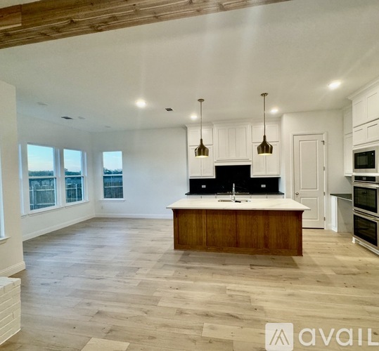 A spacious kitchen with wooden floors and a central island.