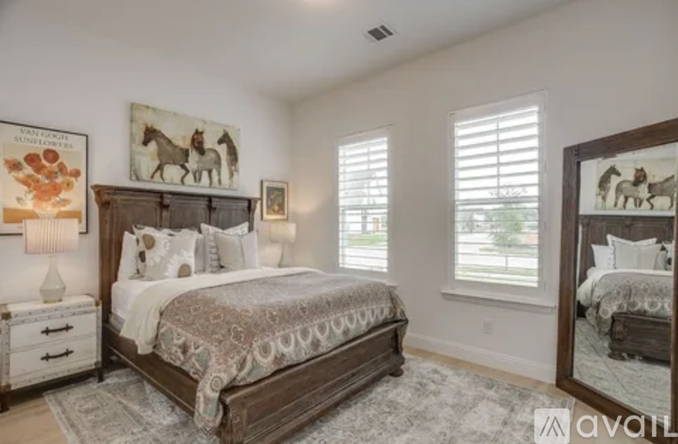 A bedroom with a large bed and a mirror on the wall.