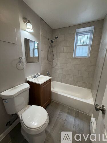A white toilet sits next to a white sink in a bathroom.