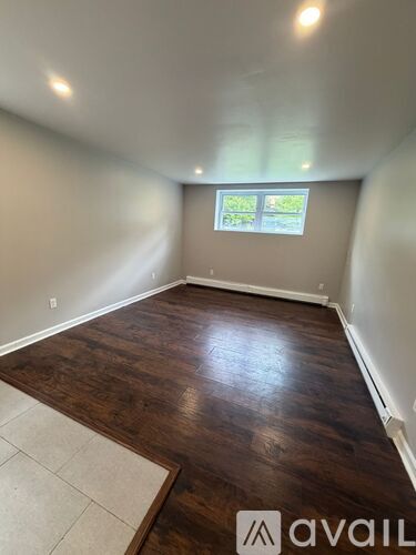 A room with wooden flooring and a window.