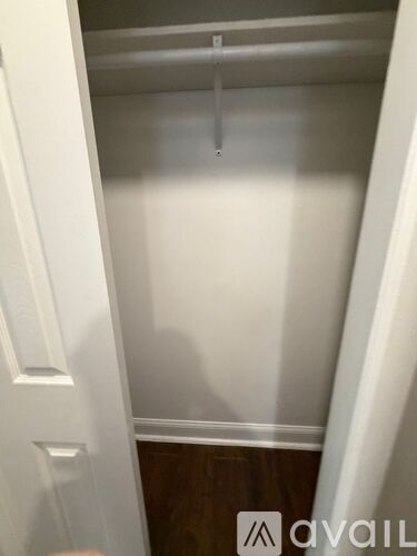 A white closet with a hanger on the rod.