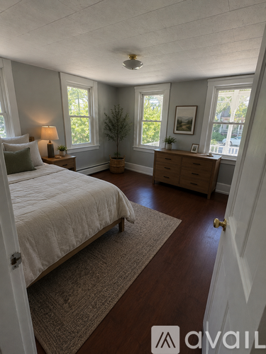 A bedroom with a bed, dresser, and window.