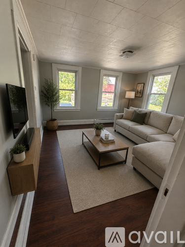 A living room with a white couch and a wooden coffee table.