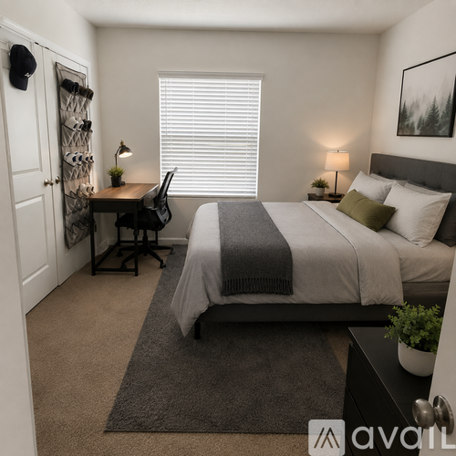 A bedroom with a bed, desk, and chair.