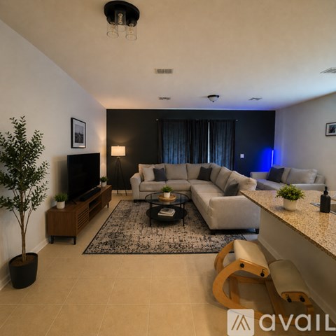 A living room with a grey couch, a black television, and a coffee table.