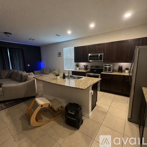 A kitchen with granite countertops and a white island.