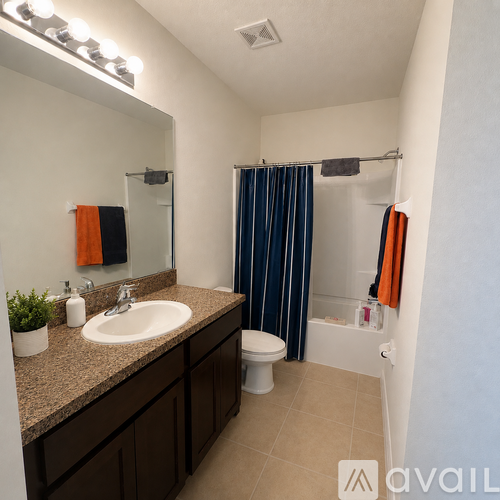 A bathroom with a sink, mirror, toilet and shower.