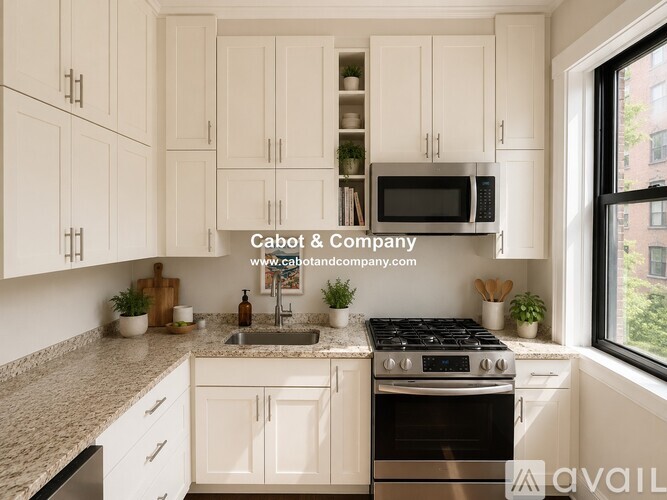 A kitchen with white cabinets and a black stove top.