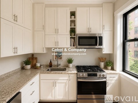 A kitchen with white cabinets and a black stove top.