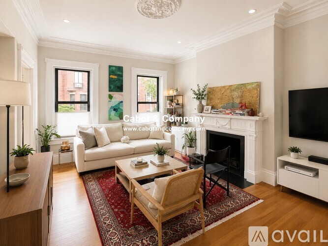 A living room with a white couch, a fireplace, and a television.