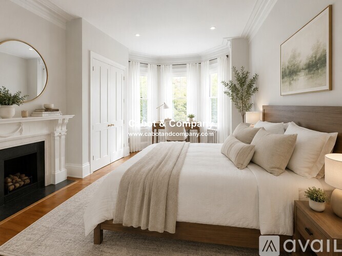 A bedroom with a large bed and a fireplace.