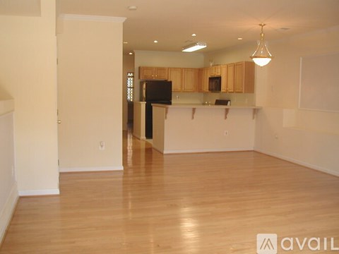 A spacious kitchen with wooden floors and cabinets.
