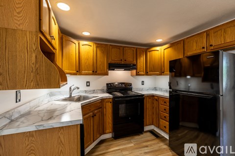 A kitchen with wooden cabinets and a marble countertop.