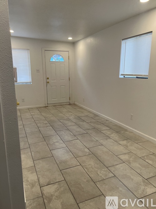 A room with a tiled floor and a door with a window above it.