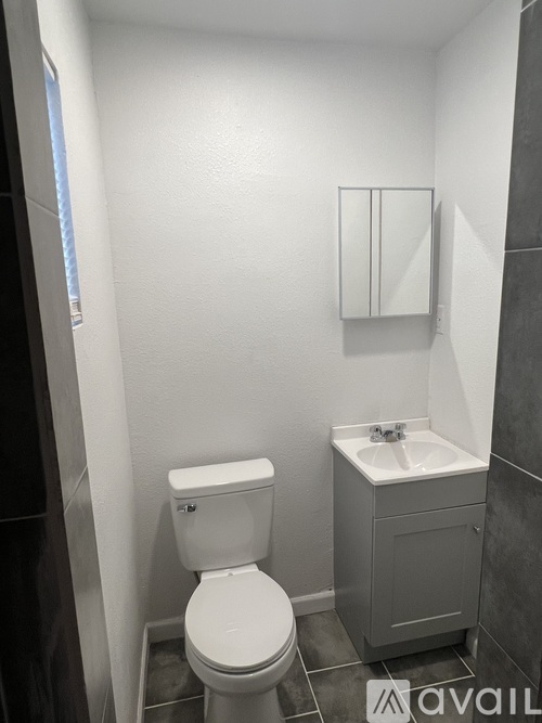 A white toilet sits next to a sink in a small bathroom.