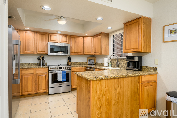A kitchen with wooden cabinets and a granite countertop.