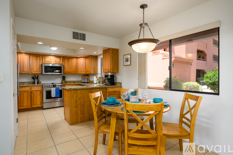 A kitchen with wooden cabinets and a dining table set for four.