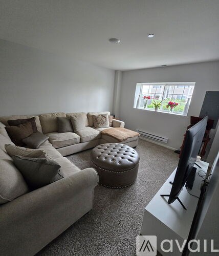 A living room with a grey couch and ottoman.